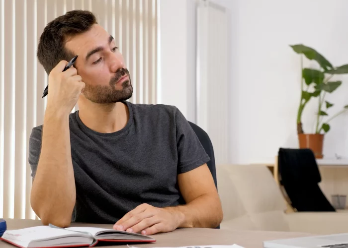 homem-escrevendo-no-caderno-em-sua-mesa-colocando-pensamentos-no-papel